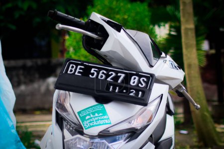 Photo for Indonesia - 27th May, 2022: Closeup of white motorcycle with black number on street - Royalty Free Image