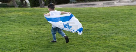 Photo for Young child running with Israeli flag. Rear view little boy running with Israel flag. - Royalty Free Image