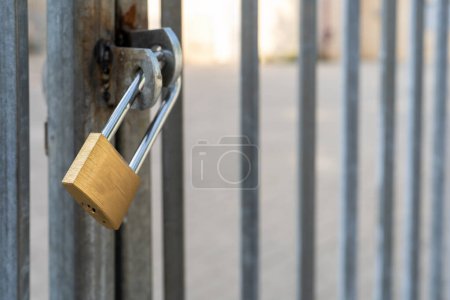 Metallic Gate With A Shiny Padlock Captures Urban Security On A Quiet City Street, Signaling Protected Premises.