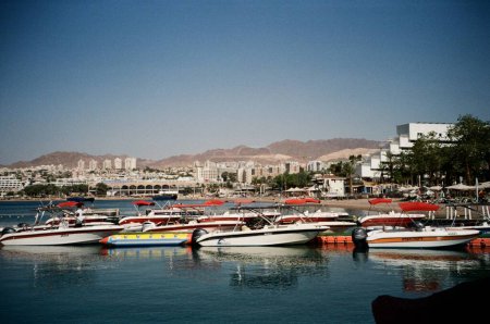 Photo for Eilat Israel, May 12, 2023. Waterfront And Mountain Backdrop. An analog photo capturing Eilats bustling waterfront with boats and distant hotels. - Royalty Free Image