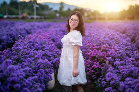 Foto de Retrato de mujer joven asiática viajero feliz con vestido blanco disfrutando en flor blanca o púrpura Michaelmas Daisy campo de flores en el jardín natural de en Chiang Mai, Tailandia, viaje relajar vacaciones - Imagen libre de derechos