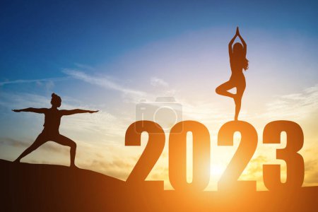 Téléchargez les photos : Happy New Year Numbers 2023, Silhouette femme pratiquant le yoga tôt le matin lever du soleil sur l'horizon arrière-plan, Santé et Happy new year concept. - en image libre de droit