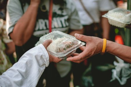 Téléchargez les photos : Les bénévoles aident à donner gratuitement de la nourriture aux sans-abri affamés : concept de service alimentaire et de don alimentaire - en image libre de droit