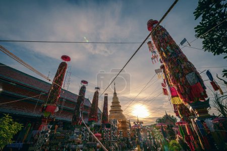Foto de Lamphun, Tailandia - 4 de septiembre de 2022: Salak yom en Wat Phra That Hariphunchai en Lamphun. La tradición de hacer mérito, los árboles de lotería teñidos altos están decorados con papel de diferentes colores y artículos de ropa para rendir homenaje a las almas - Imagen libre de derechos