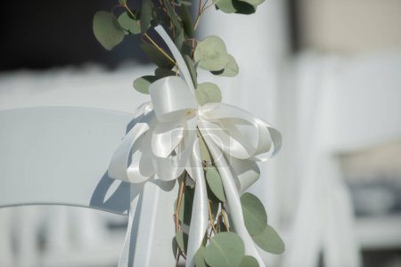 Foto de Sillas blancas en filas con arcos blancos y plantas verdes en la isla de la ceremonia de boda - Imagen libre de derechos