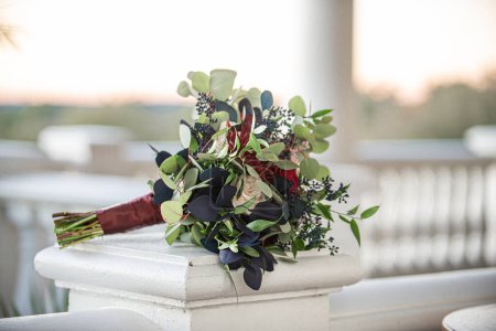 Photo for Majestic red,pink and white bouquet with blue and green leaves outdoors on fancy stair railing - Royalty Free Image