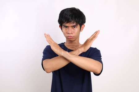 Téléchargez les photos : Portrait jeune homme asiatique debout avec geste stop hand. Isolé sur fond blanc - en image libre de droit