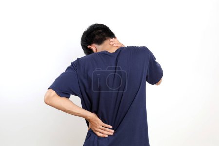 Foto de Vista posterior de un joven asiático que sufre de dolor de cuello y espalda. Aislado sobre fondo blanco con copyspace - Imagen libre de derechos