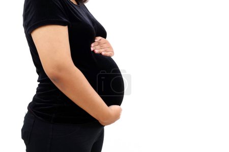 Close up pregnant woman standing while holding her belly. Isolated on white background