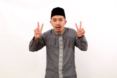 Photo for Asian muslim man standing while showing two fingers. Isolated on white background - Royalty Free Image