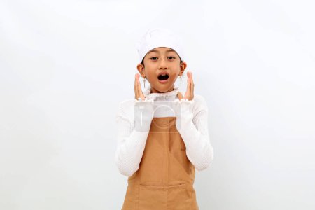 Photo for Shocked expression of little girl in chef uniform standing with open mouth. Isolated on white background - Royalty Free Image