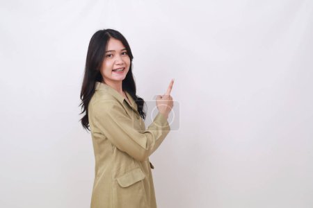 Photo for Side view of young civil servant woman standing while pointing beside her - Royalty Free Image