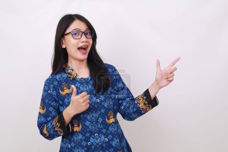Photo for Surprised Asian female in batik korpri, indonesian traditional uniform pointing sideways - Royalty Free Image