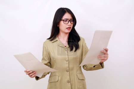 Photo for Angry young teacher holding paper with confused expression - Royalty Free Image