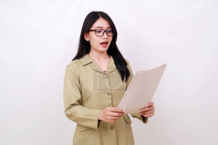 Photo for Shocked Attractive young teacher standing while holding and reading paper - Royalty Free Image