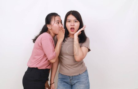 Foto de Mujer asiática incitando a su amiga. Concepto de chismes. Aislado sobre blanco - Imagen libre de derechos
