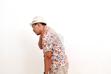 Foto de Hombre asiático viajero sintiéndose mal, dolor en el hombro. Aislado sobre fondo blanco - Imagen libre de derechos