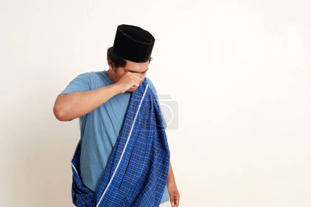 Téléchargez les photos : Triste asiatique musulman garçon debout tout en pleurant. Isolé sur blanc avec copyspace - en image libre de droit