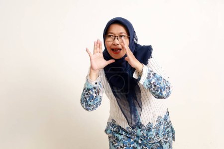 Photo for Asian elderly muslim woman standing while shouting or announcing to sideways - Royalty Free Image