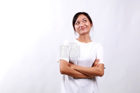 Young thoughtful minded happy woman of Asian ethnicity 20s wear casual white clothes look above on workspace area mock up prop up chin isolated on white background studio People lifestyle concept