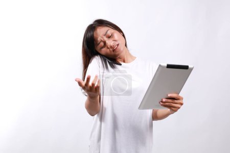 Overworked young asian woman. College student woman multitasking while talking on the cellphone, using tablet.