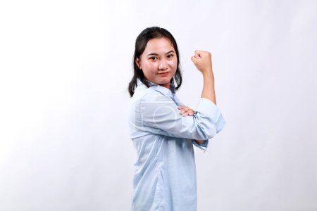 Vue de côté jeune femme d'affaires forte employé montrant les muscles biceps à la main isolé sur fond blanc