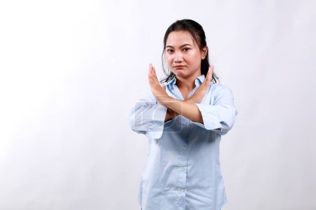 Portrait of young asian woman showing stop, cross prohibition sign, forbid smth, refusing, standing over white background