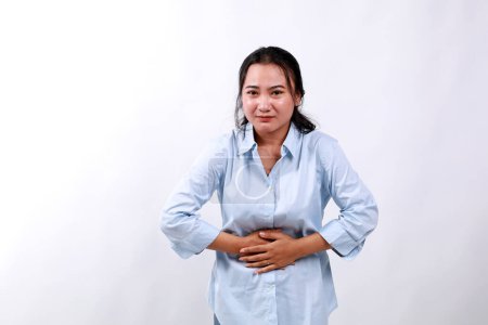 Asiatique Femme ayant mal au ventre, pliant et tenant les mains sur le ventre, inconfort des crampes menstruelles