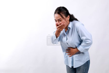 Femme asiatique souffrant de maux d'estomac et de nausées sur fond blanc. Intoxication alimentaire