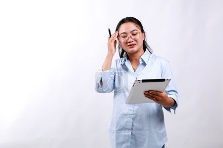 Porträt einer asiatischen Geschäftsfrau, die mit besorgtem, gestresstem und aufgeregtem Gesicht auf ihr digitales Tablet blickt. Isoliert auf Weiß