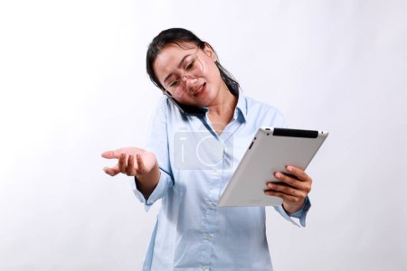 Überarbeitete asiatische Geschäftsfrau. Geschäftsfrau Multitasking beim Telefonieren mit dem Tablet.