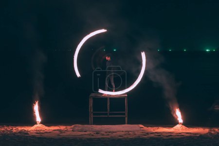 Téléchargez les photos : Summer Travel concept de vacances, Homme filant la laine d'acier de feu avec réflexion de l'eau sur la mer dans la fête de club de plage la nuit à Koh Samui, Thaïlande - en image libre de droit