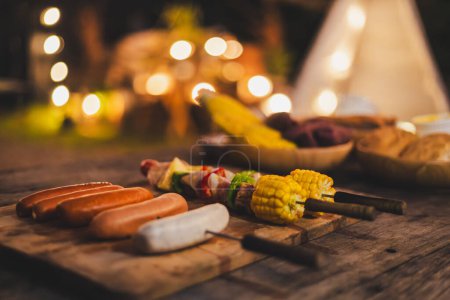 Photo for Family making barbecue meat grill in dinner party camping at night - Royalty Free Image
