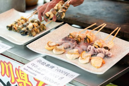 Téléchargez les photos : Kyoto Japon - 25 mai 2018 : BBQ Grill Saint-Jacques et poulpe brochette est populaire japonais street food au marché frais au Japon - en image libre de droit