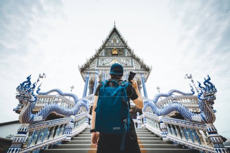 Foto de Viajero solo asiático o fotógrafo hombre con cámara y mochila turismo en el templo Wat Pak Nam Khaem Nu, Chanthaburi, Tailandia, concepto de vacaciones de viaje - Imagen libre de derechos