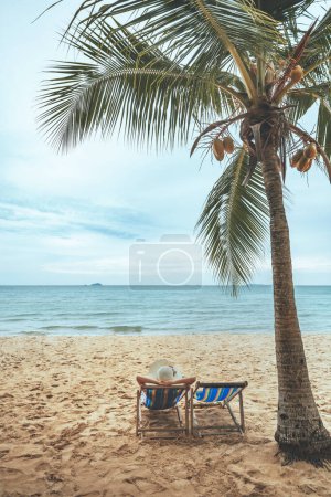 Téléchargez les photos : Summer beach travel vacation concept, Happy traveler asiatique femme avec chapeau relax sur chaise plage à Pattaya, Chon Buri, Thaïlande - en image libre de droit