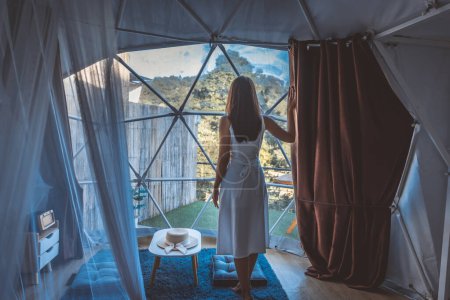Téléchargez les photos : Voyage vacances concept glamping, Happy traveler asiatique femme se détendre à l'intérieur d'une tente dôme de camping de luxe dans Mon Jam, Chiang Mai, Thaïlande - en image libre de droit