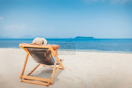 Téléchargez les photos : Summer beach travel vacation concept, Happy traveler asiatique femme avec chapeau relax sur chaise plage à Koh Rap, Samui, Surat Thani, Thaïlande - en image libre de droit