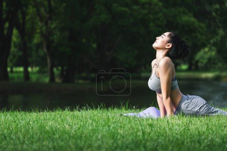 Téléchargez les photos : Fitness femme asiatique faire de l'exercice de yoga et se détendre avec des vêtements de sport dans le parc vert en été, concept de mode de vie sain - en image libre de droit