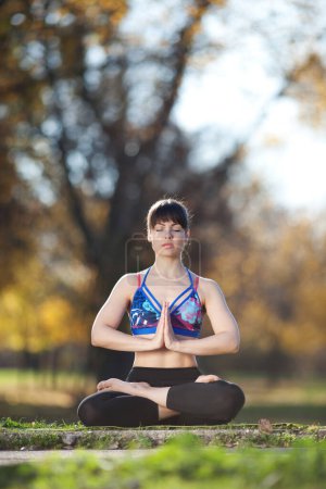 Foto de Mujer joven practicando yoga al aire libre - Imagen libre de derechos