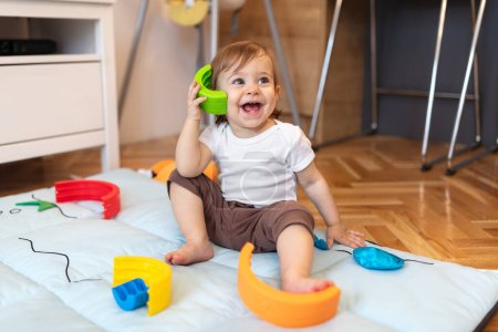 Photo for Adorable one year old child playing with plastic toys at home, shallow depth of field - Royalty Free Image
