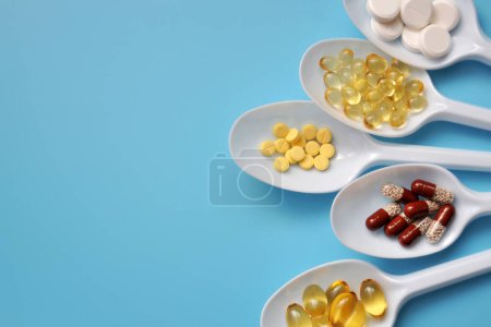Photo for Tablets, capsules, dietary supplements, vitamins on white spoons. Medical background with pills - Royalty Free Image