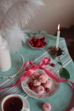 pink macarons served with cherries