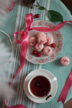 pink macarons served with cherries