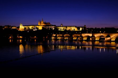 Night view of Charles Bridge which is a medieval stone arch bridge that crosses the Vltava river in Prague, Czech Republic on July 27, 2022.