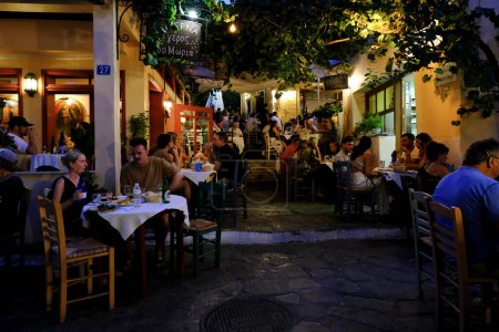 Téléchargez les photos : Les gens s'assoient sur la terrasse d'un café dans le quartier de Plaka à Athènes, Grèce le 15 août 2022. - en image libre de droit