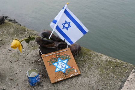Téléchargez les photos : The flag of Israel in  the memorial of shoes remembering the Holocaust victims on the bank of the River Danube in downtown Budapest, Hungary on December 22, 2022. - en image libre de droit