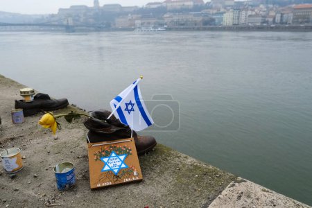 Téléchargez les photos : The flag of Israel in  the memorial of shoes remembering the Holocaust victims on the bank of the River Danube in downtown Budapest, Hungary on December 22, 2022. - en image libre de droit