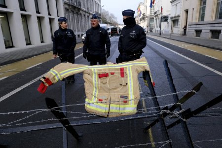 Foto de Firefighter jackets are laid on barricades as police officers stand during a protest for better working conditions, in Brussels, Belgium, January 27, 2023. - Imagen libre de derechos