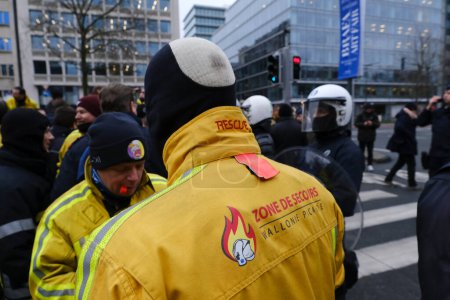 Foto de Police officers stand guard as they obstruct the firefighters from blocking the traffic on the road during a protest for better working conditions, in Brussels, Belgium, January 27, 2023. - Imagen libre de derechos